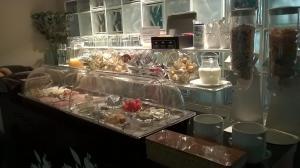 a counter with a bunch of food in plastic containers at Kokodor in De Haan