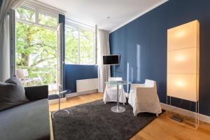 sala de estar con paredes azules y mesa en The New Yorker BOARDINGHOUSE, en Colonia