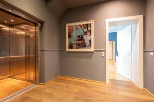 a hallway with a painting on the wall next to a door at The New Yorker BOARDINGHOUSE in Cologne