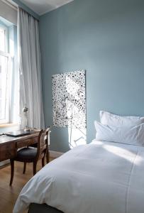 1 dormitorio con cama, escritorio y ventana en The New Yorker BOARDINGHOUSE, en Colonia