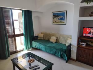 ein Wohnzimmer mit einem Sofa und einem TV in der Unterkunft Albufeira INN - Casa da Peneda - Bellavista T1 in Albufeira