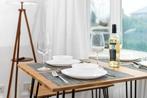 a table with a bottle of wine and two glasses at Luxury 3 Bedroom House - Garden - Parking - Interior Designed - Netflix - Wifi - 52H in Birmingham