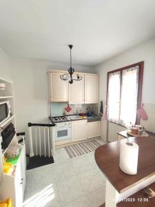 uma cozinha com armários brancos e um forno com placa de fogão em La casa di Gabry em Vada