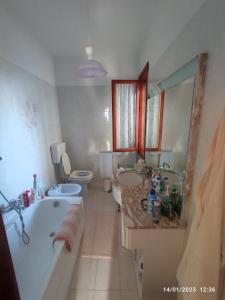 uma casa de banho com uma banheira, um lavatório e um WC. em La casa di Gabry em Vada