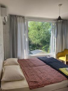 ein Bett in einem Schlafzimmer mit einem großen Fenster in der Unterkunft Kokhta guest house On the mountain in Jvari