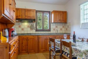 a kitchen with wooden cabinets and a table with wine glasses at [COSTA REI] *500 metri dal mare* Free Parking/Wifi in Costa Rei