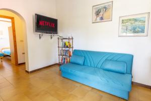 a blue couch in a living room with a tv at [COSTA REI] *500 metri dal mare* Free Parking/Wifi in Costa Rei