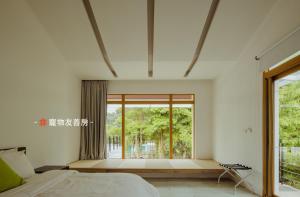 a bedroom with a bed and a large window at Dao Villa in Dongshan