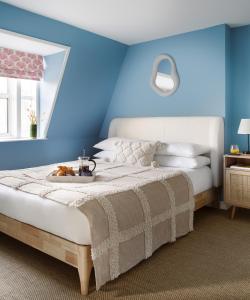 a bedroom with a bed with a blue wall at Lux Mews House Portobello 4 bed in London