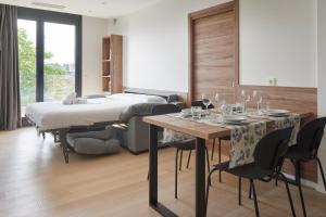 een slaapkamer met een bed en een tafel en stoelen bij MANTULENE Apartments - Basque Stay in San Sebastian