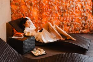 Hotel Podklasztorze في سولييوف: امرأة في ثوب أبيض مستلقية على كرسي
