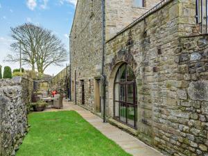 an old stone building with a patio and grass at 2 Bed in Malham 94261 in Airton