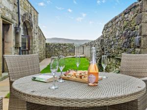 a table with a bottle of wine and glasses at 2 Bed in Malham 94261 in Airton
