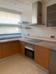 a kitchen with wooden cabinets and a stove top oven at Home SEA&DREAMS Ifach in Calpe