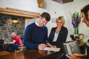 a man and a woman standing at a table at Bushmills Inn Hotel & Restaurant in Bushmills