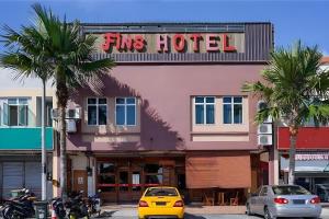 a yellow car parked in front of a fire hotel at Fins Hotel in Alor Setar