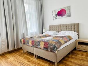łóżko z kołdrą w sypialni w obiekcie Hotel Klimt w Wiedniu