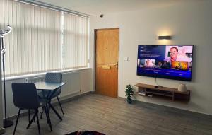 133B HiBrid Home في أوكسفورد: غرفة معيشة مع طاولة وتلفزيون بشاشة مسطحة