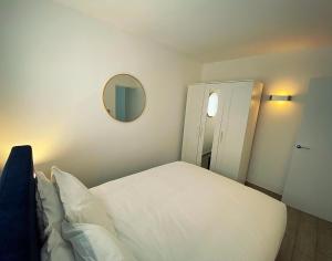 a bedroom with a white bed and a mirror at 133B HiBrid Home in Oxford