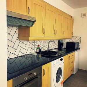a kitchen with wooden cabinets and a washing machine at 133 Home in Oxford