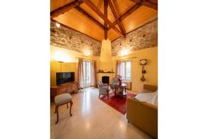 - un salon avec un canapé et une télévision dans l'établissement Locanda Villa d' Epoca, à Aurigeno
