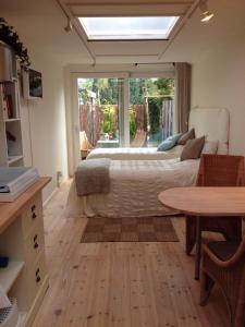 um quarto com uma cama, uma mesa e uma janela em BBBoekelo appartement em Boekelo