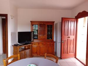 uma sala de estar com uma televisão e um armário de madeira em Bandi House em San Teodoro