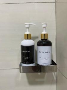 due bottiglie di shampoo e sapone su uno scaffale di Oak Nest a Kericho