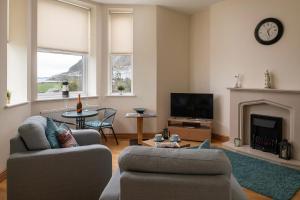 a living room with a couch and a fireplace at Puffin View in Llanfairfechan