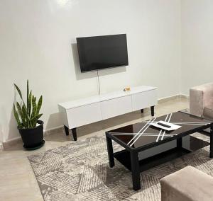 a living room with a tv on a white wall at Oak Nest in Kericho