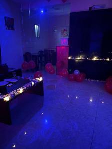 een kamer met ballonnen en een podium met blauwe lichten bij Samaa Eva Resort in Abha