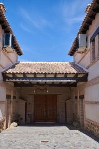 a large building with a large wooden door at Casas Rurales El Aljibe, Jara in Argés