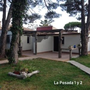 ein weißes Haus mit einem Baum und einem Hof in der Unterkunft La posada in Chiclana de la Frontera