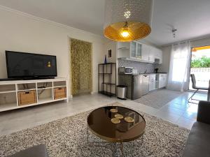 ein Wohnzimmer mit einem Tisch und einem TV in der Unterkunft Vista del Mar 2 in Morro del Jable