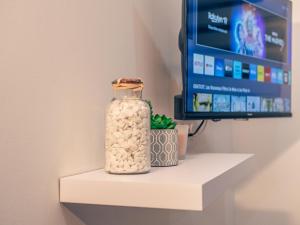 una botella de cristal en un estante con TV en Grand Studio, en Le Blanc-Mesnil