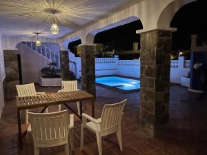 eine Terrasse mit einem Tisch und Stühlen sowie einem Pool in der Unterkunft Vista del Mar 2 in Morro del Jable