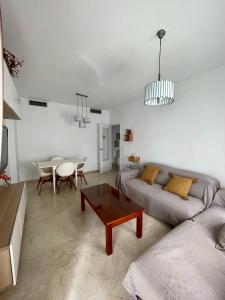 uma sala de estar com um sofá e uma mesa em Magnífico Apartamento en Sevilla em Sevilha