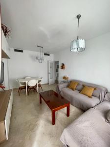 salon z kanapą i stołem w obiekcie Piso AZORES-FIBES w Sewilli
