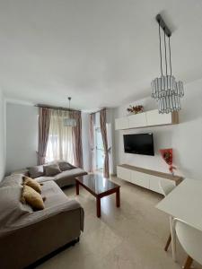 a living room with two couches and a tv at Magnífico Apartamento en Sevilla in Seville
