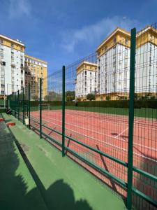 kort tenisowy z dwoma budynkami w tle w obiekcie Piso AZORES-FIBES w Sewilli