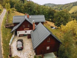 una vista aerea di un fienile rosso con un'auto parcheggiata fuori di Chata Říp a Rokytnice nad Jizerou