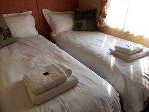 a hotel room with two beds with towels on them at Heaste Retreat in Broadford