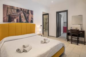 a bedroom with a bed with two pairs of slippers at B&B Casa Giunchiglia in Noto