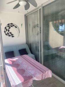 Zimmer mit einem rosa Bett und einem Fenster in der Unterkunft Appart rdc front de mer, calme 4MER4 in Argelès-sur-Mer