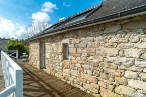 GouesnachにあるKilliouarn - Charmante maison à 15min des plagesの木造の通路付きの石造建築 +4枚の写真