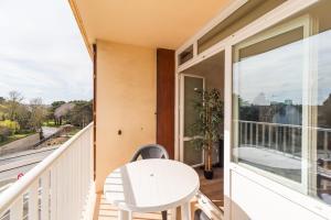 een balkon met een witte tafel en een raam bij L’Escapade Bretonne - Appt à 10min de la plage in Saint-Brieuc