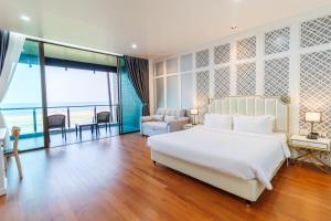a bedroom with a large white bed and a balcony at Sea Sand Sun Hua Hin Resort in Phetchaburi