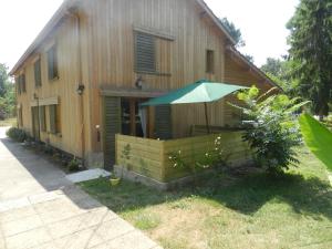 a house with a green umbrella in front of it at HERMITAGE DURAS in Anzex +6 photos