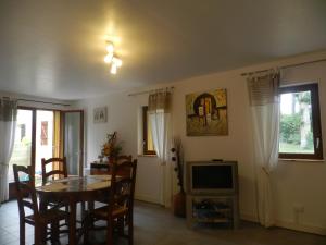 a dining room with a table and a television at HERMITAGE DURAS in Anzex