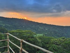a view of a mountain with the sunset in the background at Three Creeks Matale in Matale